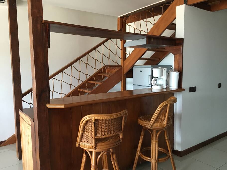 Le bar, le coin cuisine et l'escalier vers l'étage des chambres
