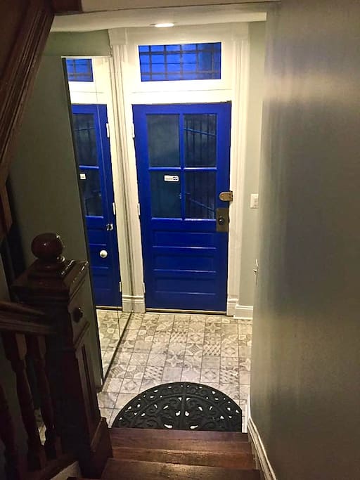 The topmost apartment in a three unit home is accessed through the side entrance, but even here you enter in style with a cobalt blue door and a printed ceramic entryway.