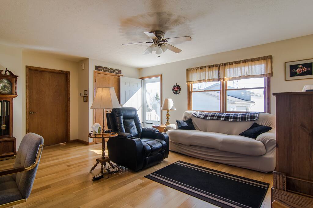 Sunny and bright living area with electric reclining chair and comfortable couch.