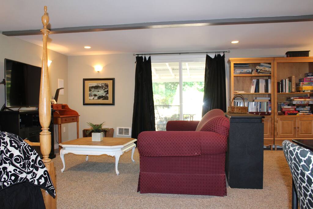Suite leads to outdoor sitting area with view of green belt, private television using Sling TV and writing desks
