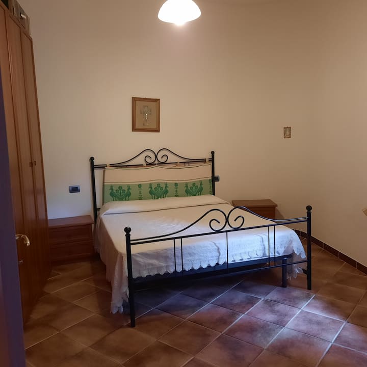 Velika spavaća soba s pogledom na privatno dvorište koje se sastoji od kreveta,ormara 6ante, komode s ogledalom i noćnih ormarića