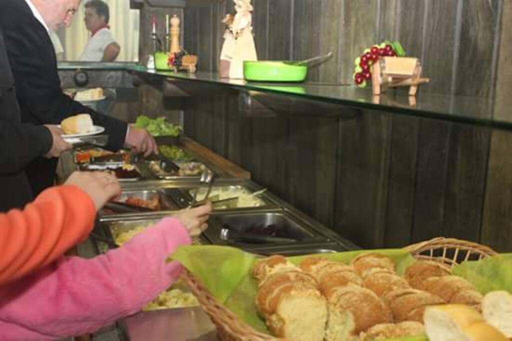 Buffet com comida Italiana, ou gastronomia local Churrasco.