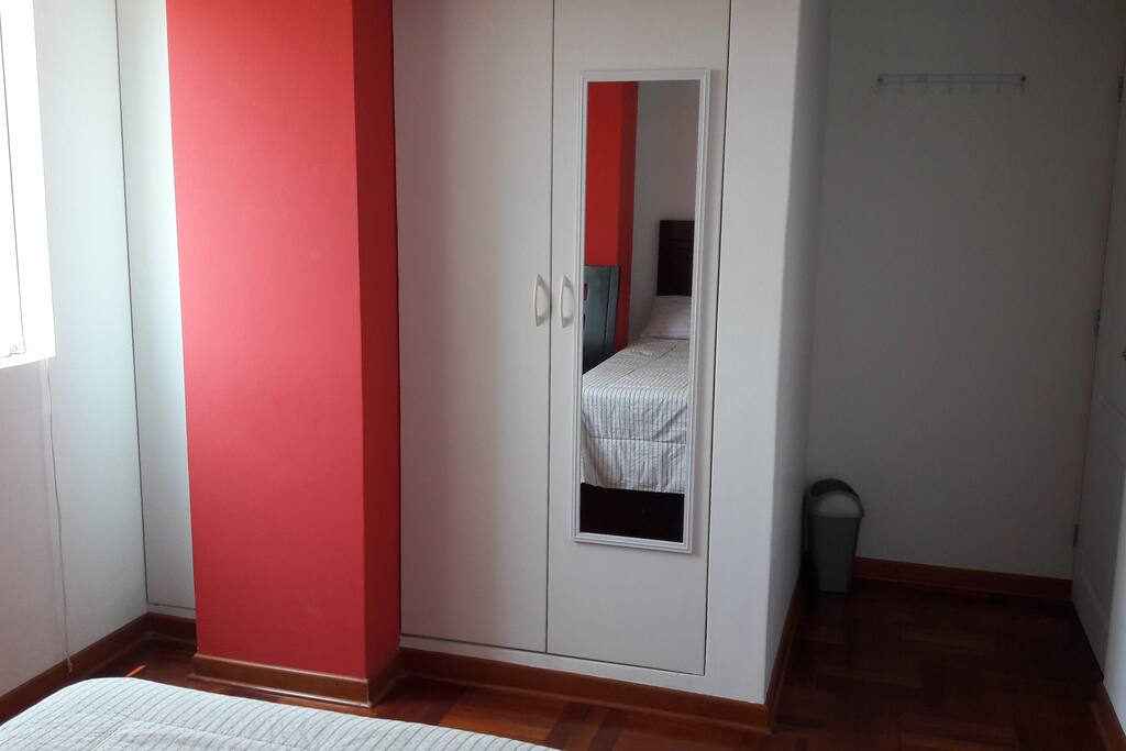 Closet incorporado, espejo y accesorios que se encuentran en la habitación.