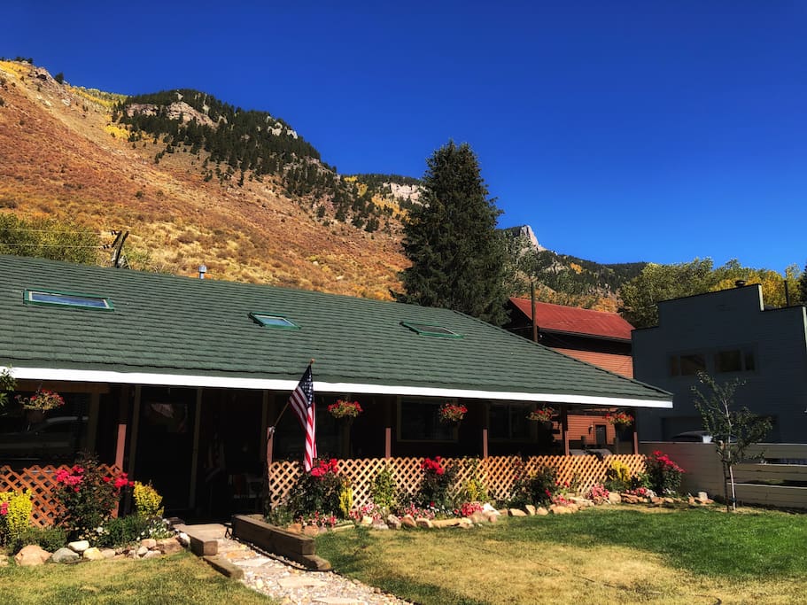 Exterior photo of our house, shot during fall, with lions head framed in the cliffs behind the house