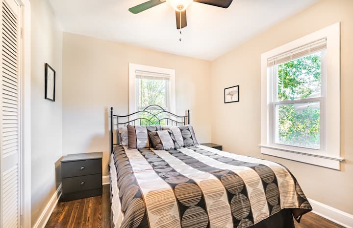 Slaapkamer #2 met een queensize bed, nachtkastjes met lampen, dressoir en een kast.