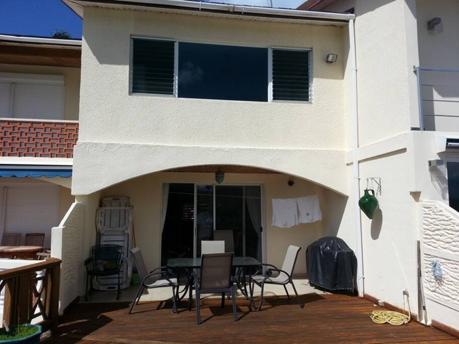 The rear view with large table and 6 chairs for outside dining. There is a large gas BBQ for outdoor dining.