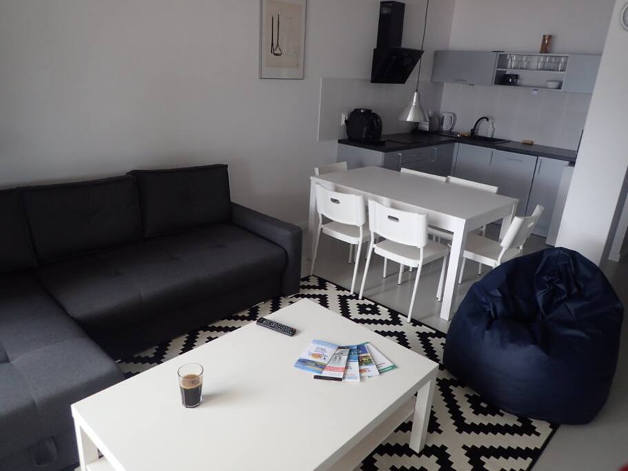 Duży salon z wygodną sofą, a także w pełni wyposażoną kuchnią