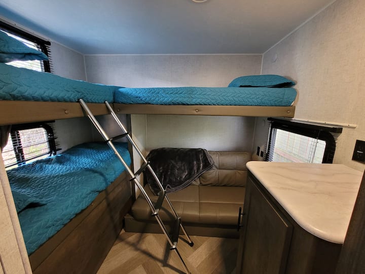 Bunk room has 3 bunk beds and a fold out couch.
