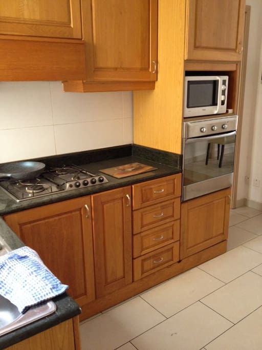 In the kitchen there is a gas cooker, oven, microwave and an electric kettle.