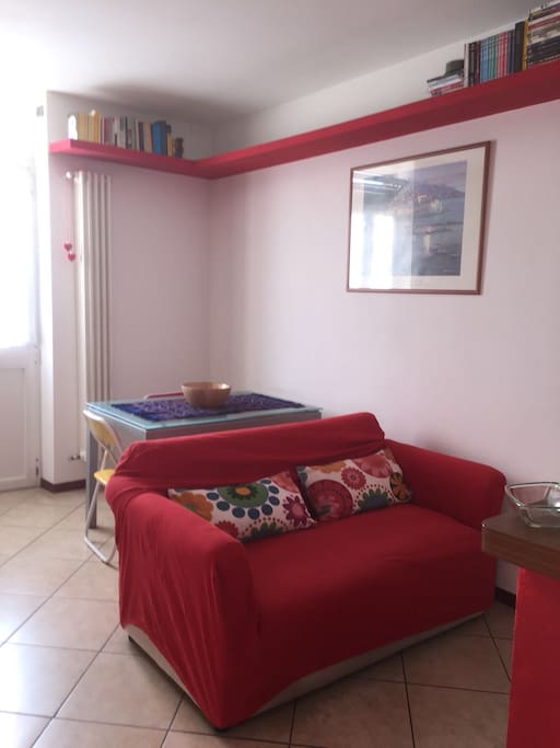 Soggiorno con cucina a vista e divano letto