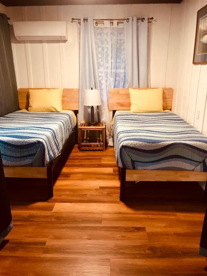 Dormitorio renovado con dos camas individuales.