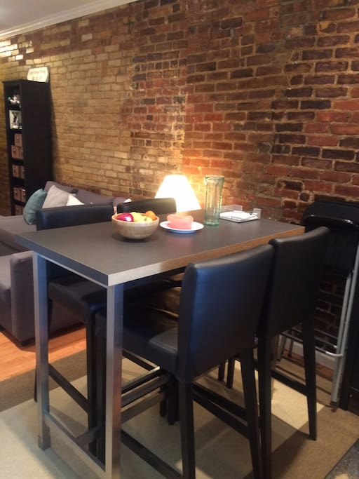 Dining table space that can seat up to 4 guests, with 3 additional folding chairs available.