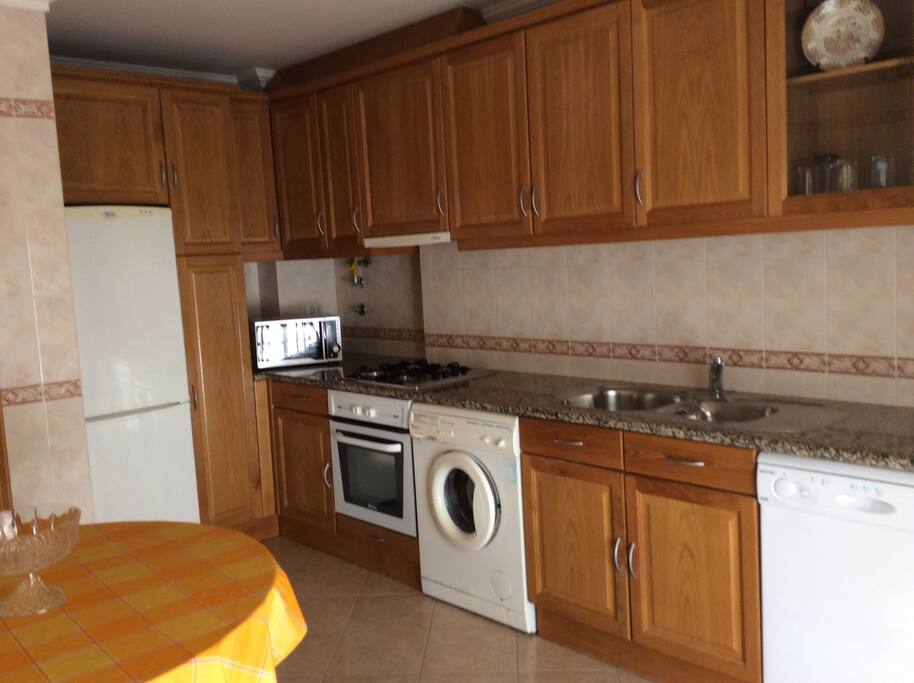 Cozinha equipada com Máquina de Lavar Roupa, Máquina de Lavar Loiça, Fogão, Forno, Microondas e Frigorifico.