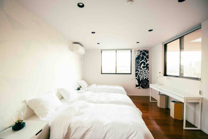 Una habitación de estilo occidental en el segundo piso (10 esteras de tatami) con acentos blancos y tela azul marino marimekko.Cuatro camas individuales están disponibles. (2 de ellos están pegados)
