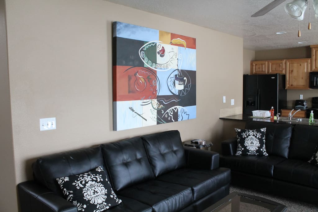 Living room with comfy leather sofas and ceiling fan.