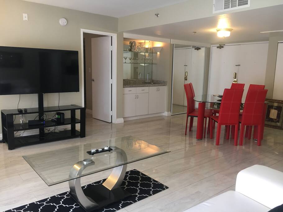 view of large HD tv and dining room table and kitchen