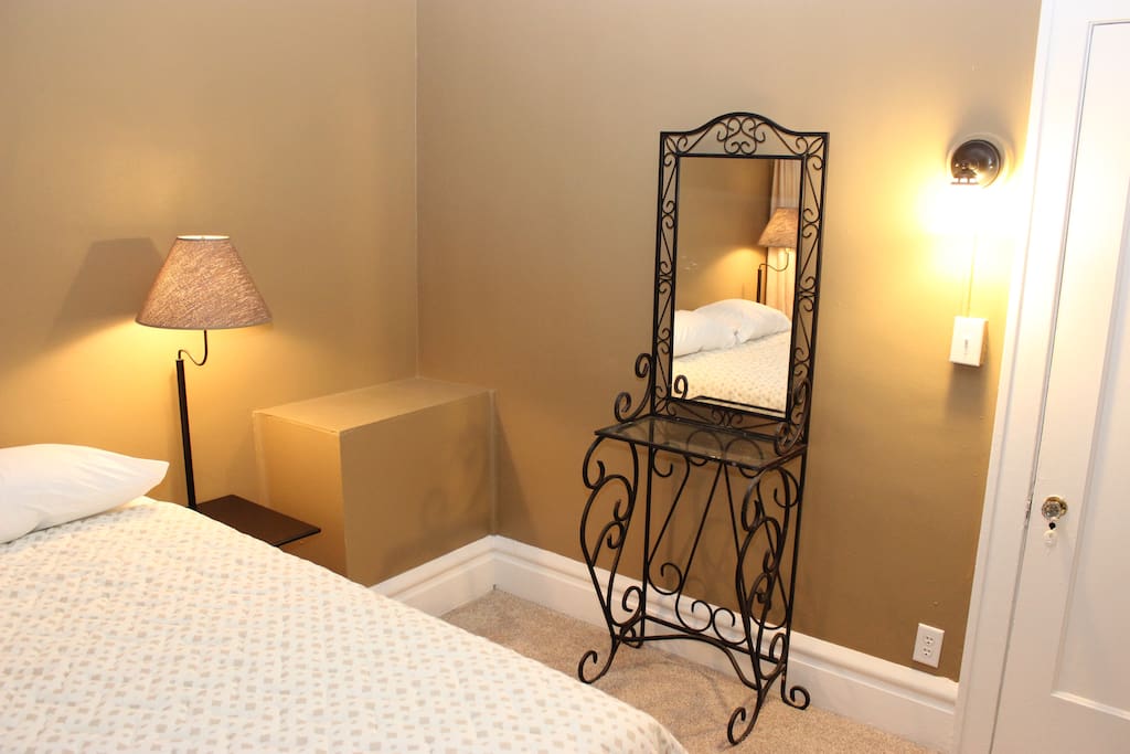 The bedroom includes a wrought-iron vanity and 2 side table/lamps.
