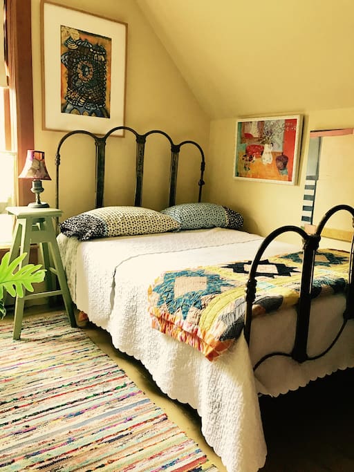 The Artemisia Bedroom is filled with inspirational and colorful original artworks. A new luxury mattress, vintage linens, a Finnish rag rug, and a bathtub filled with plants. Not your ordinary environment.