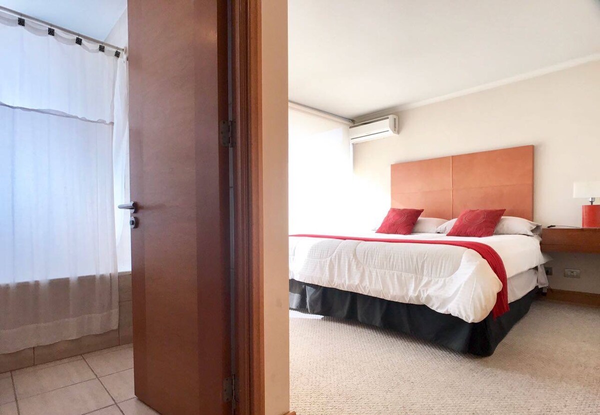 غرفة نوم داخلية بسرير بمقاس كبير وخزانة  مزدوجة وحمام.