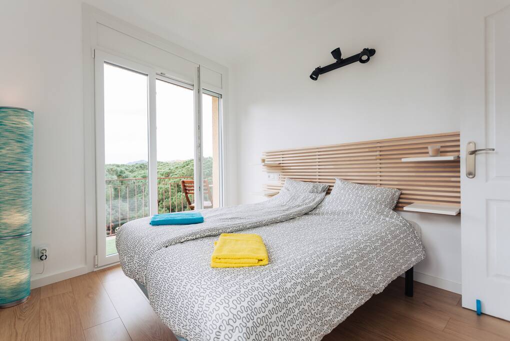 Queen size bed in a luminous room.