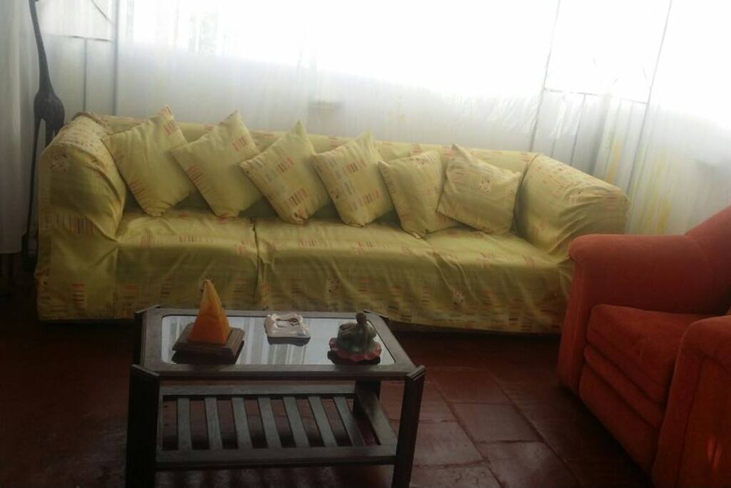 Esta es la sala, tiene un sofá de 4 cuerpos, 1 de un cuerpo y un puff