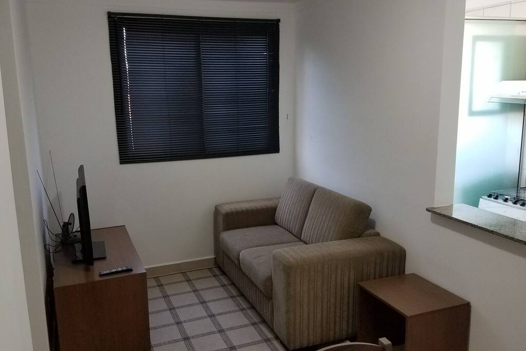 Sala de estar com sofá confortabilíssimo, TV de LED e 2 puffs