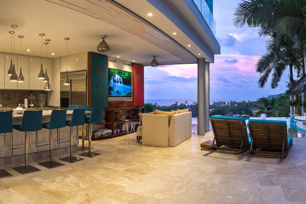 Outdoor kitchen and Poolside TV looking in from the patio