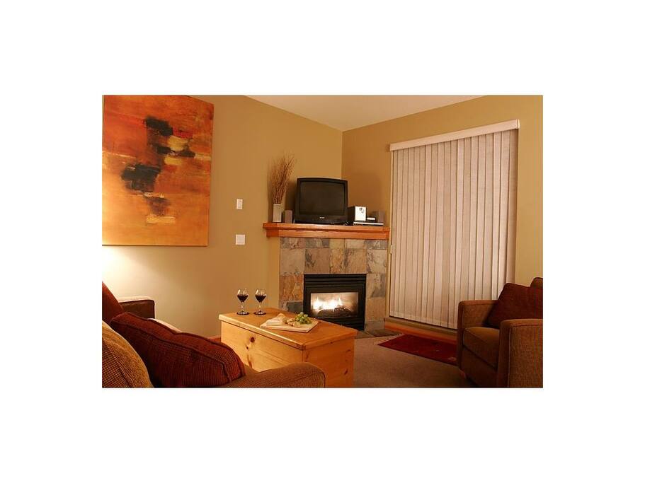 Bright comfortable living room leading onto deck. Deluxe mattress on sofa bed.