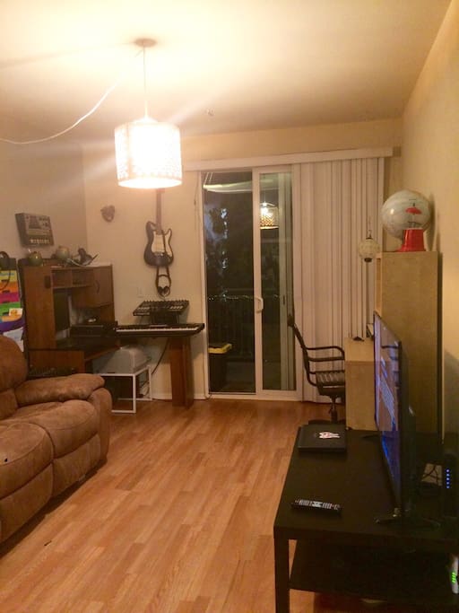 Living room. All wood floors throughout place. 55" Flat Screen TV with hundreds of cable channels including on demand. Plus roku ultra. Great balcony. Tropical landscaping.