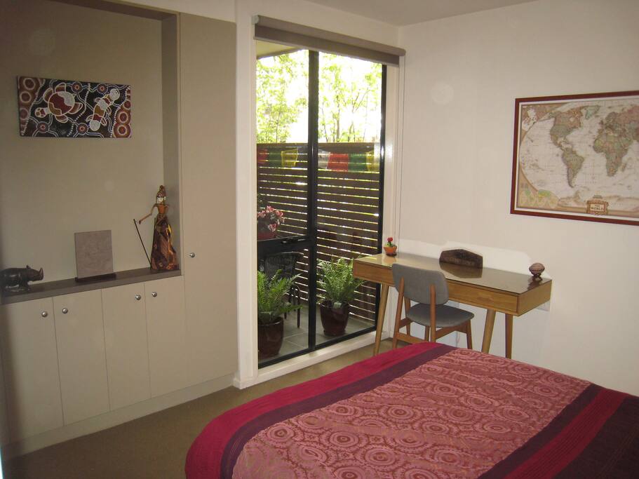 Bedroom with queen-sized bed and desk.