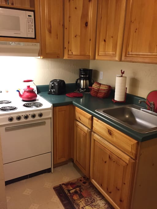 Kitchen includes stove, microwave and refrigerator.