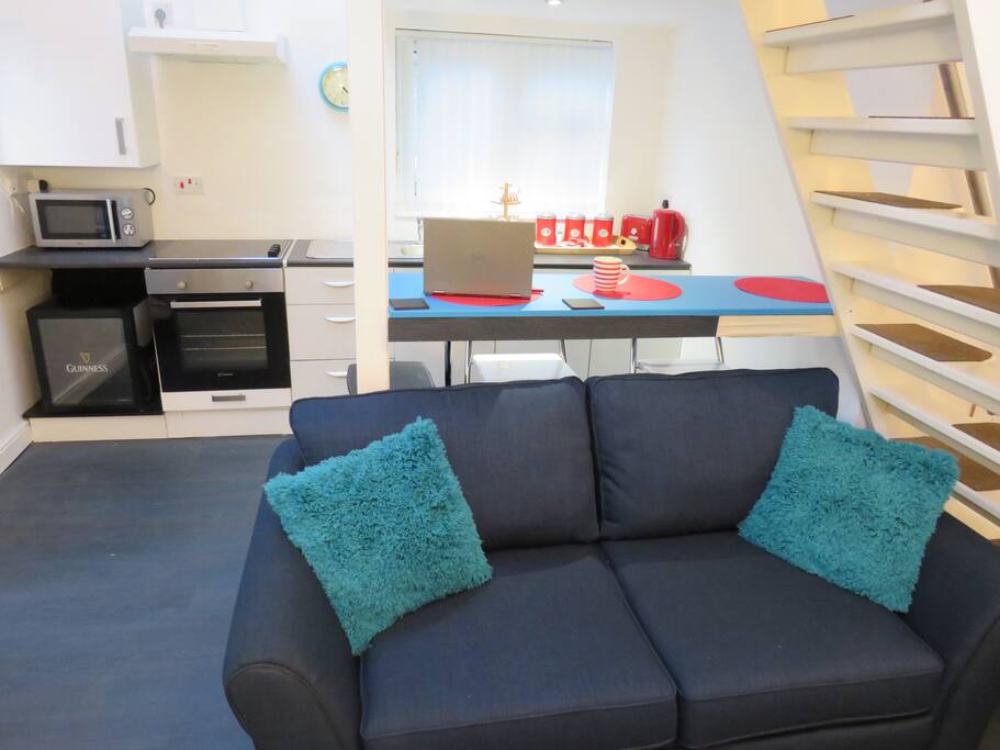 Looking from the living area, through to the Kitchen, with breakfast bar, fridge, oven, microwave, sink.