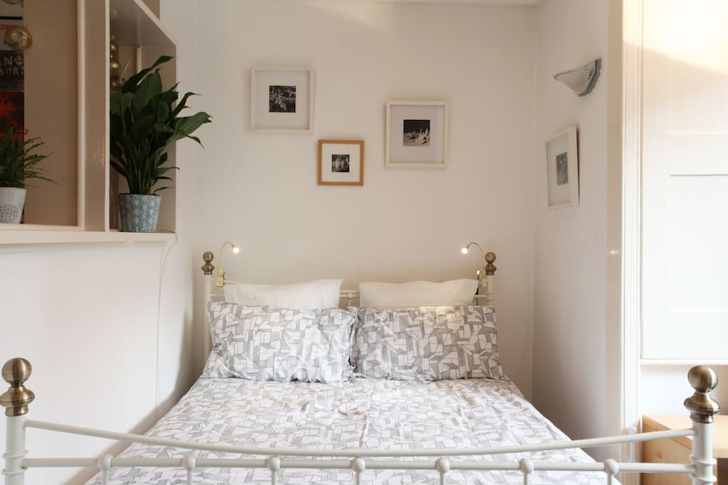 Brass antique bed surrounded by original artwork.