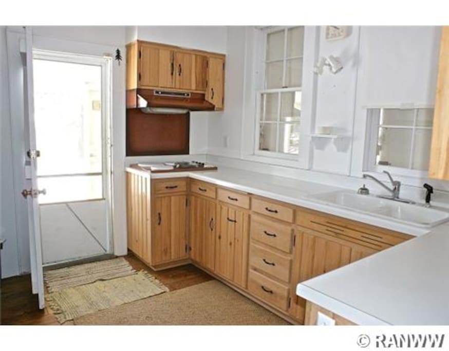 Kitchen has cooktop, sink, microwave, and fridge/freezer.