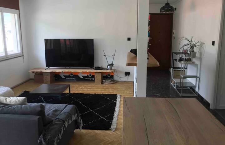 Obývacia izba s rozkladacou pohovkou, 165-cm televízorom a barom. 