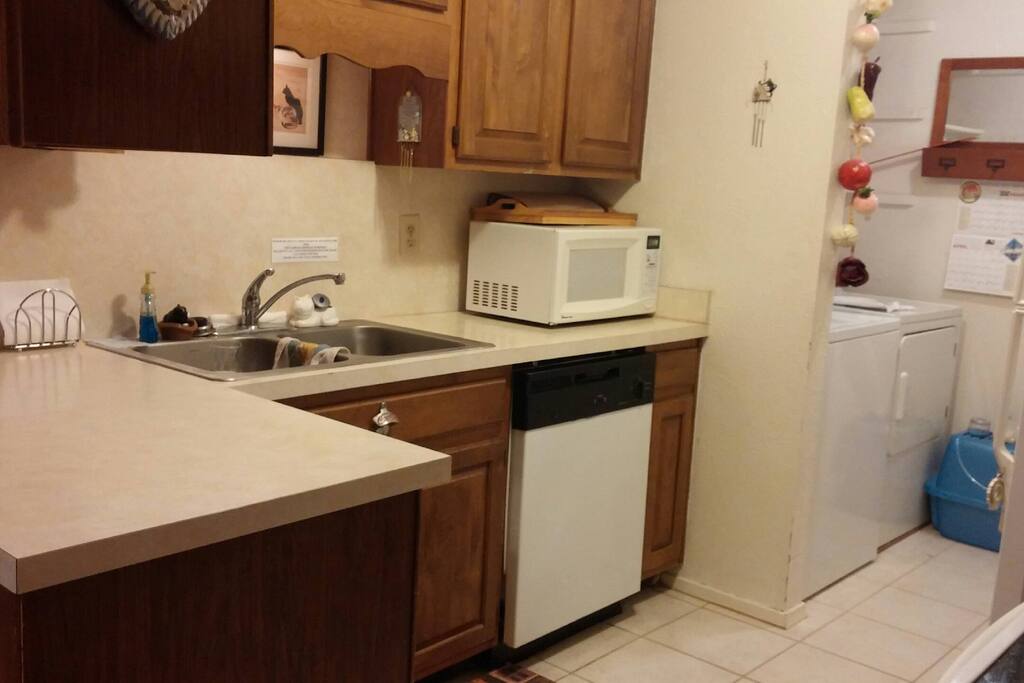 Half of the kitchen, microwave, and dishwasher shown. You can see the laundry area adjacent to the kitchen.