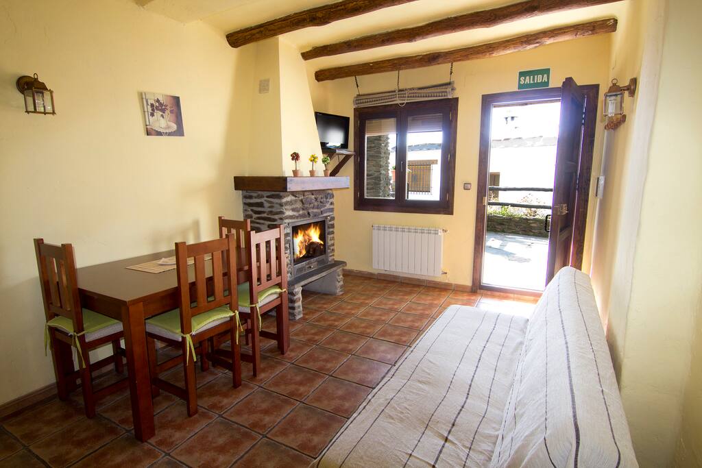 Salón-comedor con chimenea, calefacción y cocina.