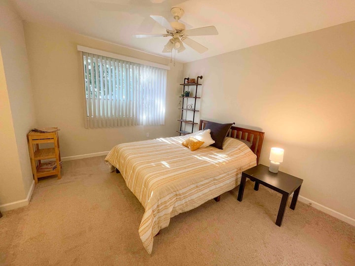 تحتوي غرفة النوم على خزانة ملابس ومرآة كاملة الطول ومروحة سقف. 