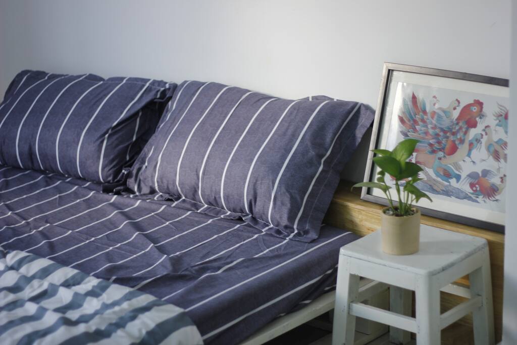 A king-sized bed in a cozy private room with a little bedside table