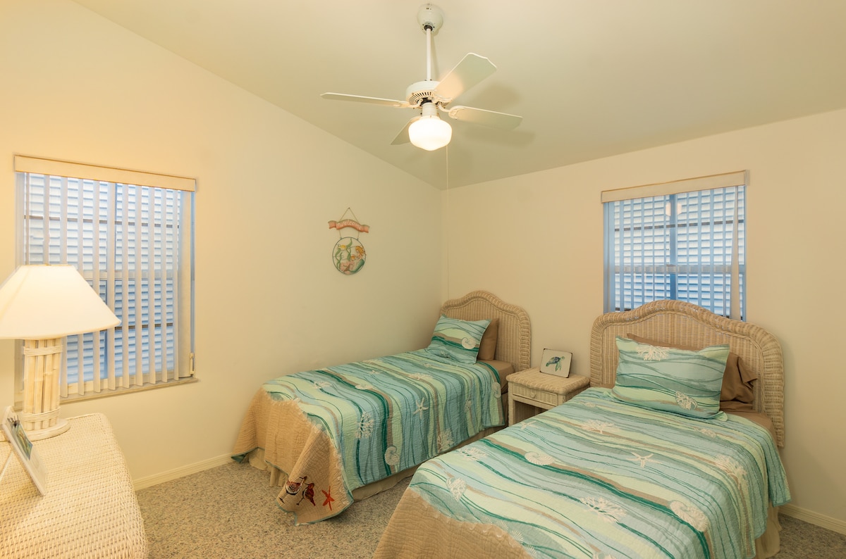 Stay at a Key Largo vacation rental with a cozy bedroom featuring twin beds! Includes beach-themed quilts, wicker furniture, and a ceiling fan. Enjoy a bright, airy space perfect for a relaxing stay in the Florida Keys. Book your retreat now!
