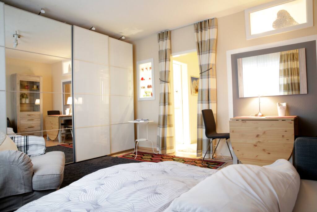 Geräumiger Schrank mit Schiebetüren hinter der sich der Fernseher verbirgt und viel Platz für alles Mögliche zum Verstauen plus Kleiderbügel Staubsauger und tolle Schubladen
Kleine Fenster zum Bad und zur Küche vermitteln viel Durchblick