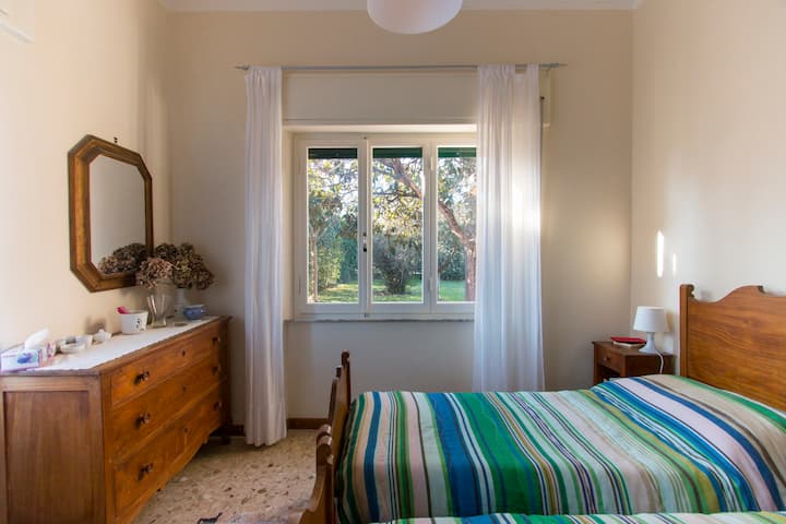 花园里有大窗户的双人卧室