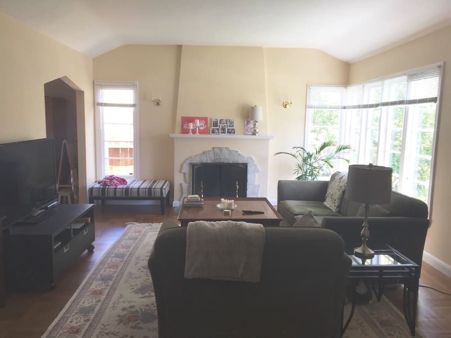 Large living room with open fireplace, 55" TV and Apple TV.