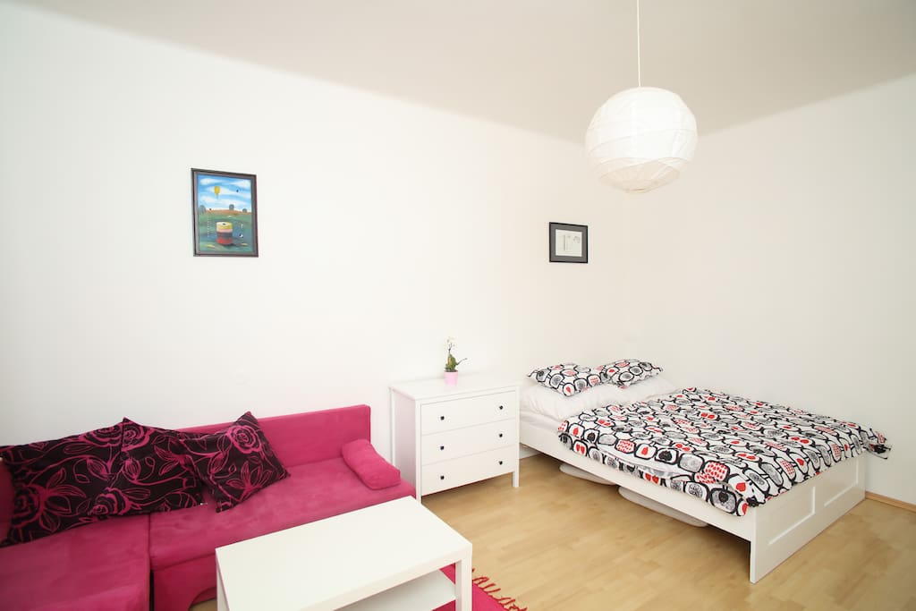 The living room features a double bed and a fold-out couch, dresser, dining table with four chairs and a stand-alone coat hanger. Using the fold-out couch, the flat sleeps up to 4 people. Pillows, covers and beddings are provided. Free WiFi is available throughout the flat.