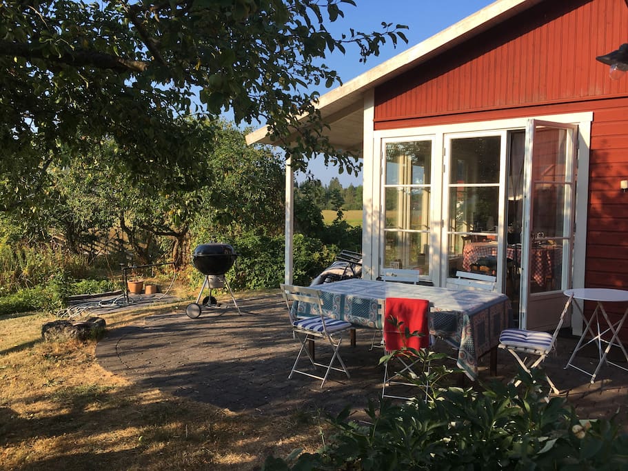 Avskild uteplats med matbord och grill. Utsikt över ängar med betande lamm. Eftermiddags - och kvällssol.