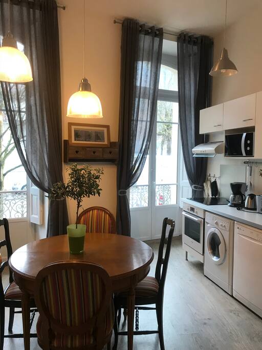 Kitchen and dining-room table. Washing machine, stove, micro wave and dishwasher.