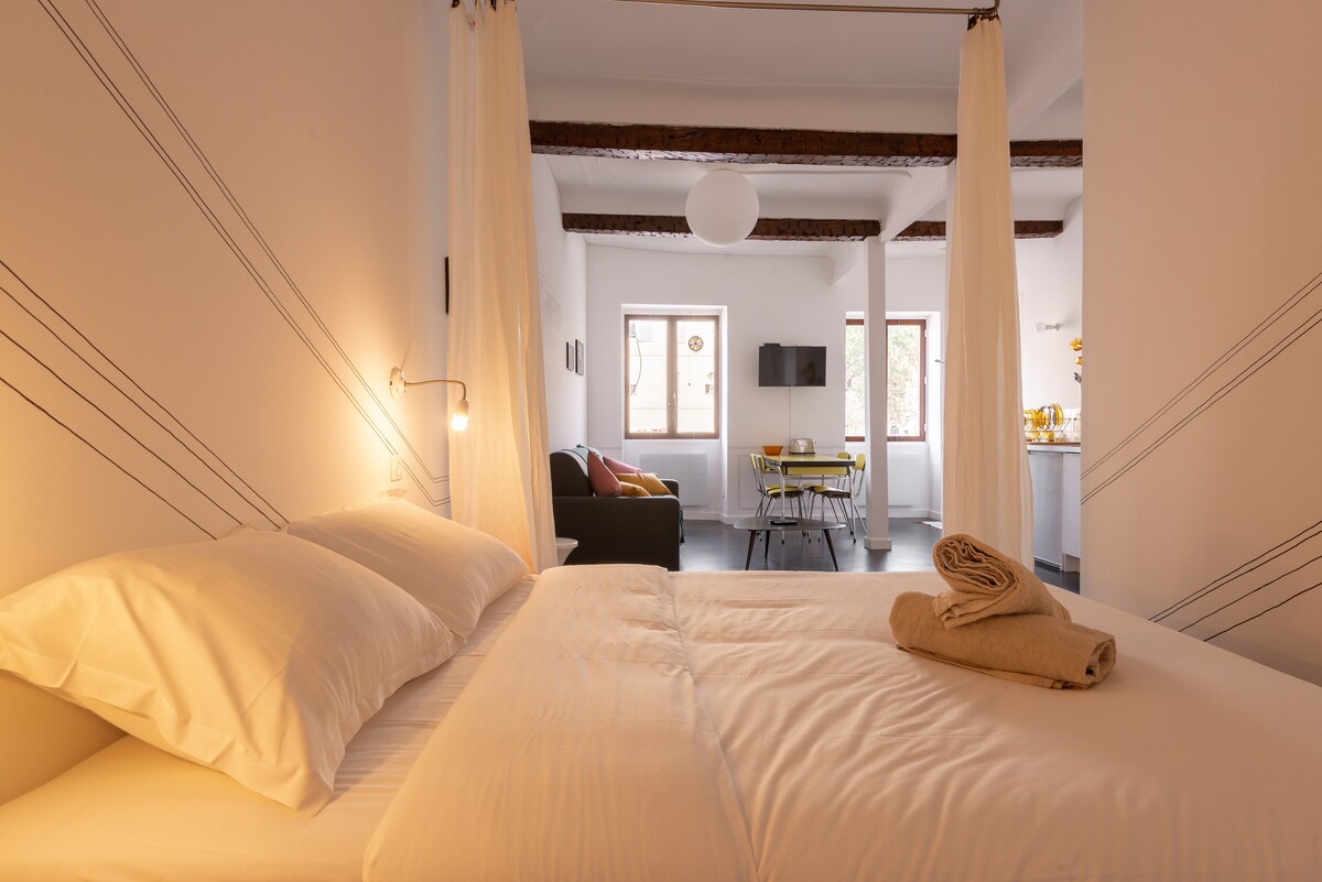 Dormitorio cómodo con cama doble cerrada por cortinas