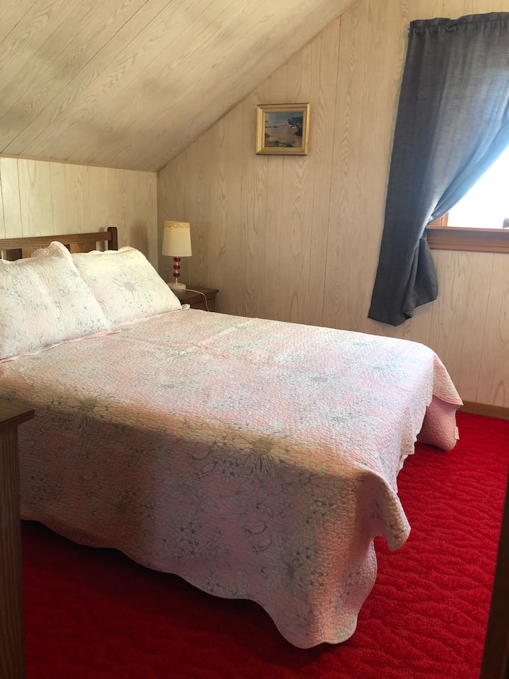 เตียงคู่ในห้องสีแดงพร้อมวิวที่งดงามของที่พักอยู่ติดกับขอบน้ำ 