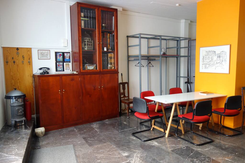 A view of the space on the left as you enter. The table can be used as a workstation and/or dining table. The cabinet on the left is not for use, it has some vintage decorative items placed in it.