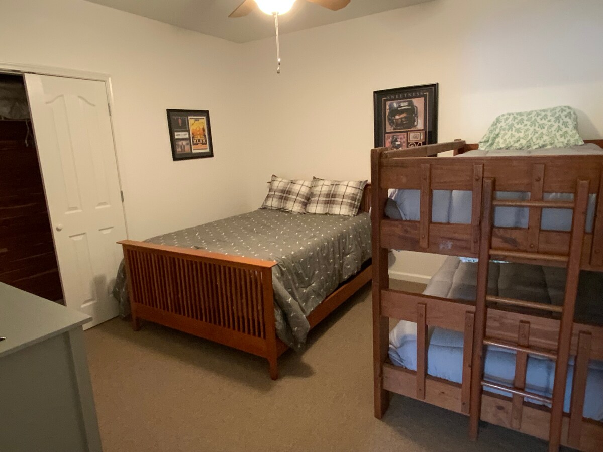 Spálňa 4 s manželskou posteľou, poschodovými posteľami, cédrovou skriňou, komodou a televízorom.